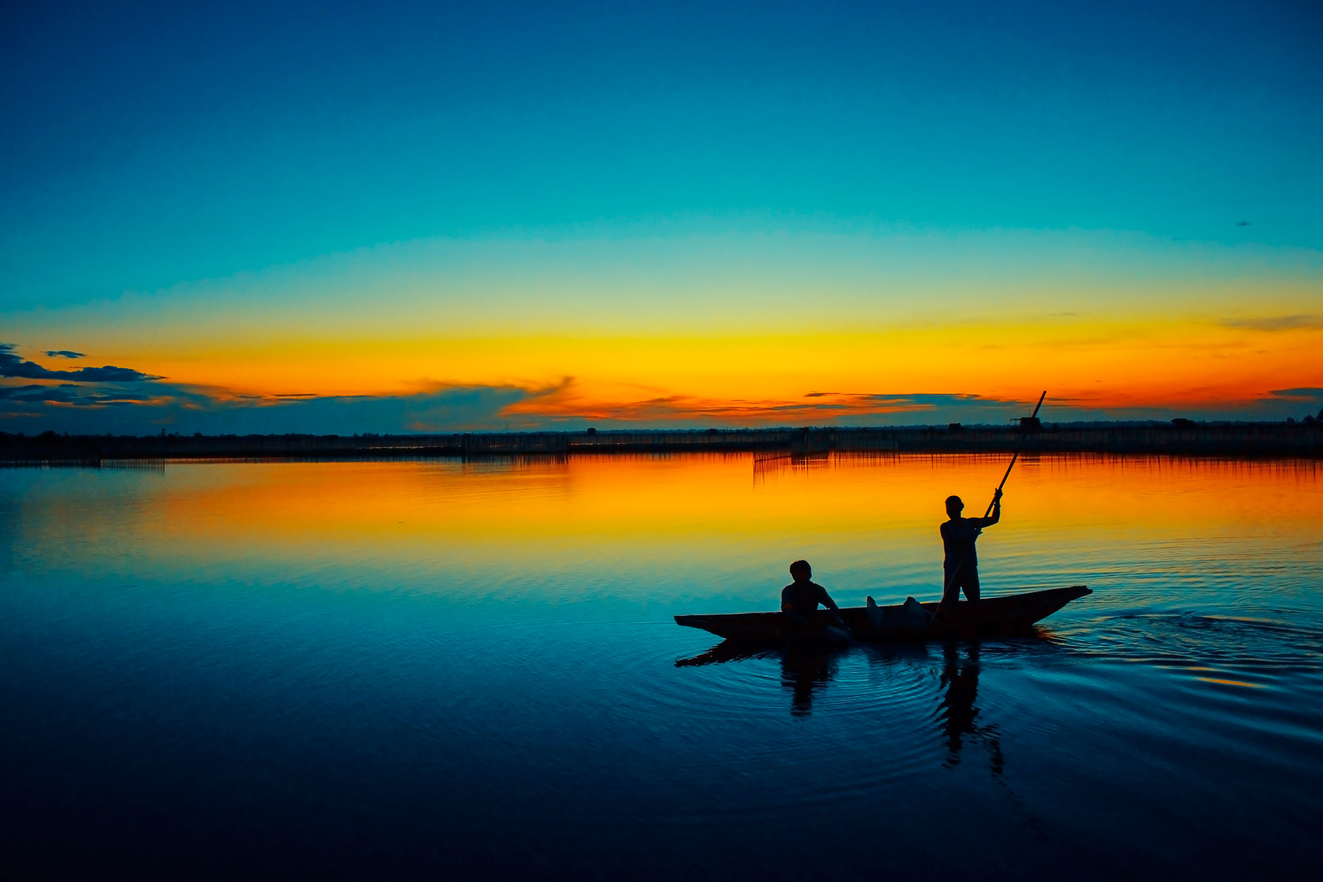 A couple of fishermen are fishing in a lagoon in Hue province, Vietnam.