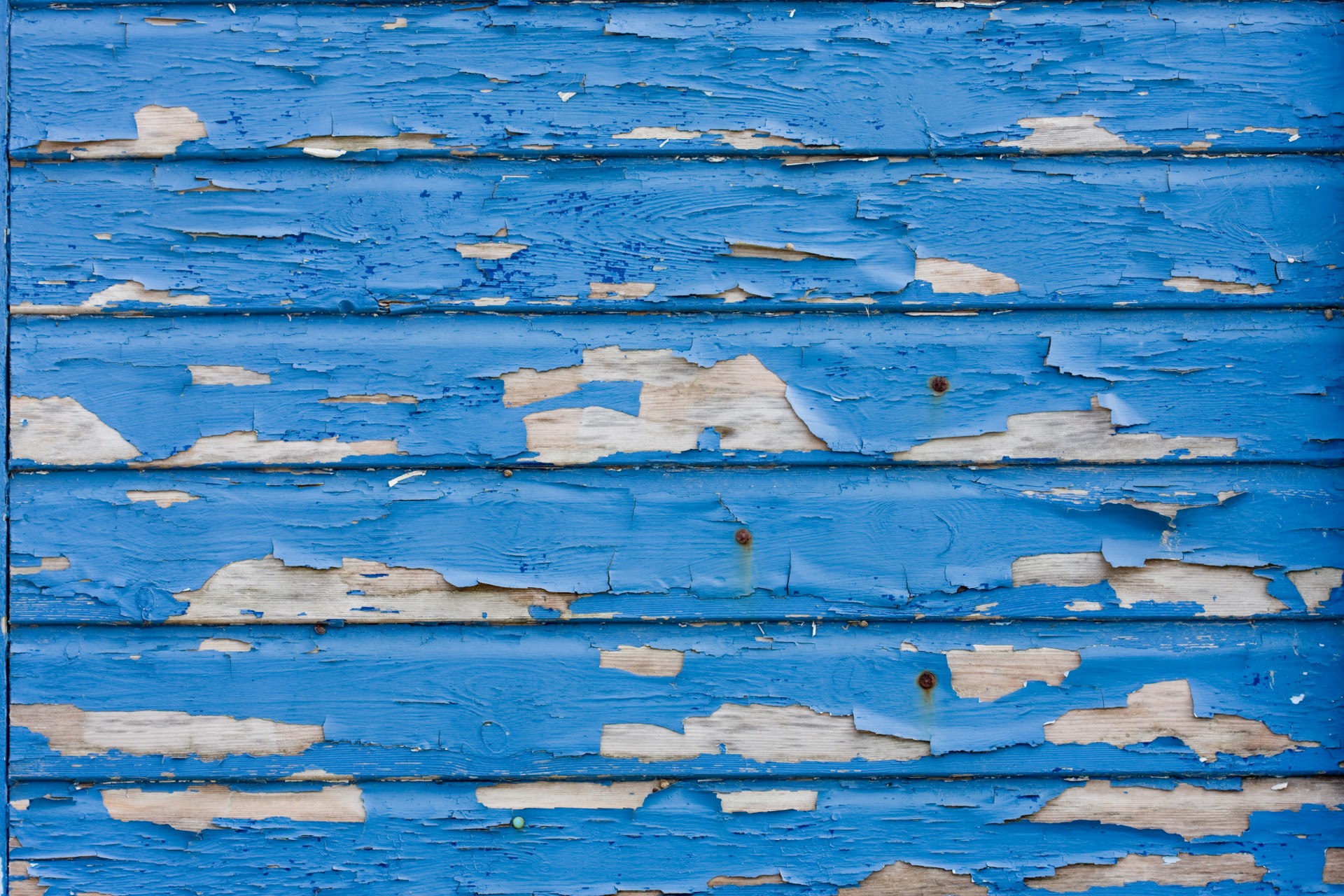 Blue flaking paint on wood texture background