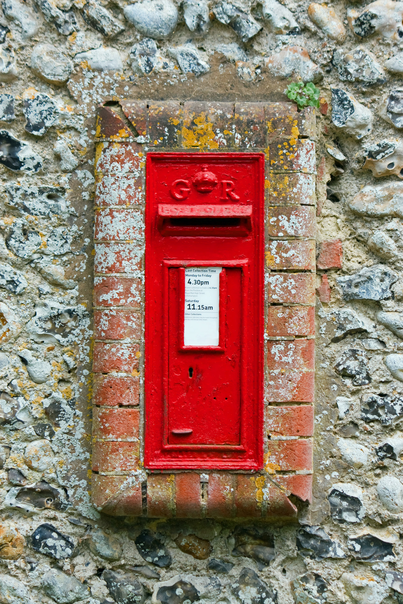 English rural red post box or mail box set in a stone wall