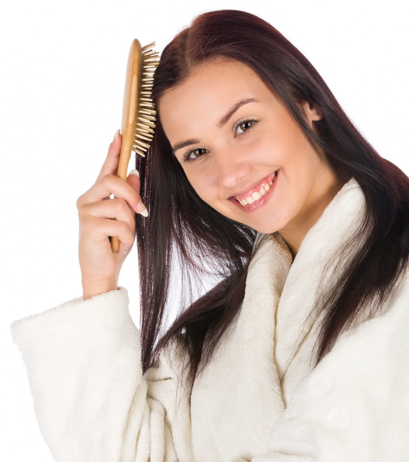 Young woman in a robe brushing her hair isolated on white background