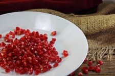 Red Pomegranate Seeds On A Plate