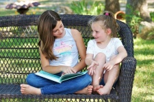 Two Children Reading Book Outdoors
