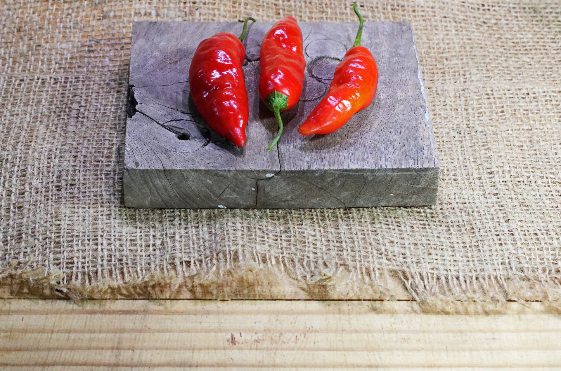 red chilis on wooden board and hessian