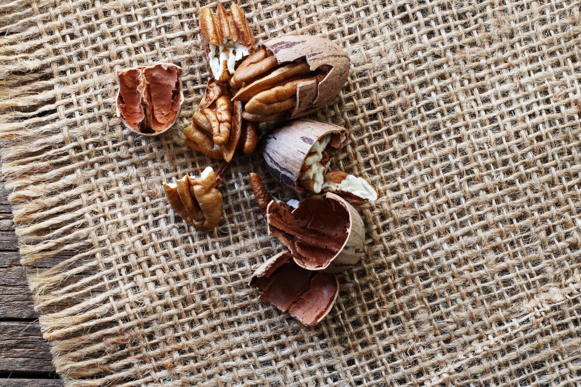 a collection of shelled pecan nuts on a piece of hessian