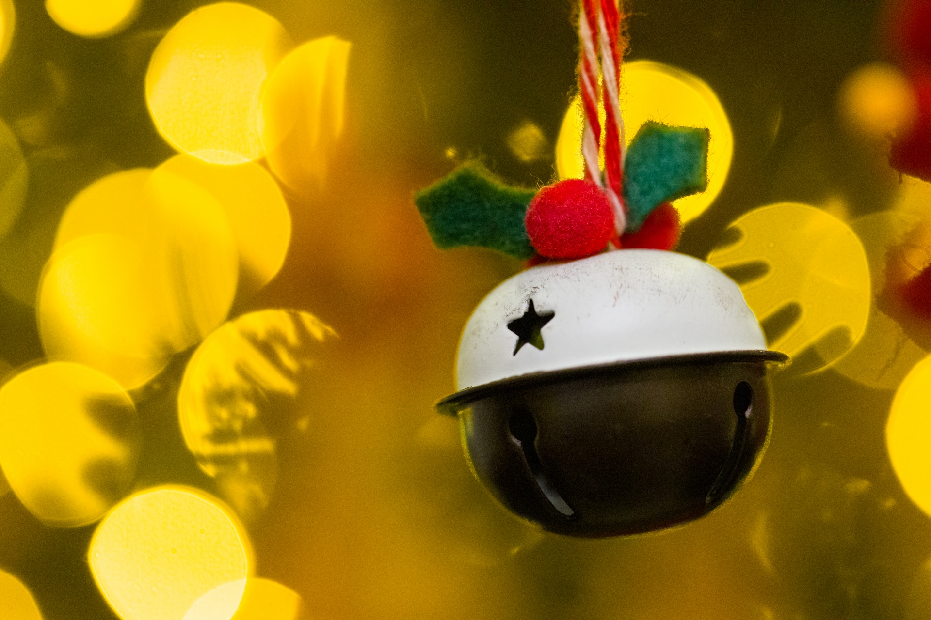 Holly jingle bell hanging with yellow bokeh background