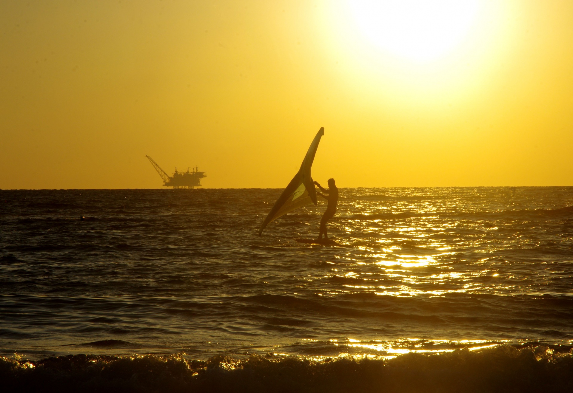 Silhouette Of Windsurfer And Oilrig
