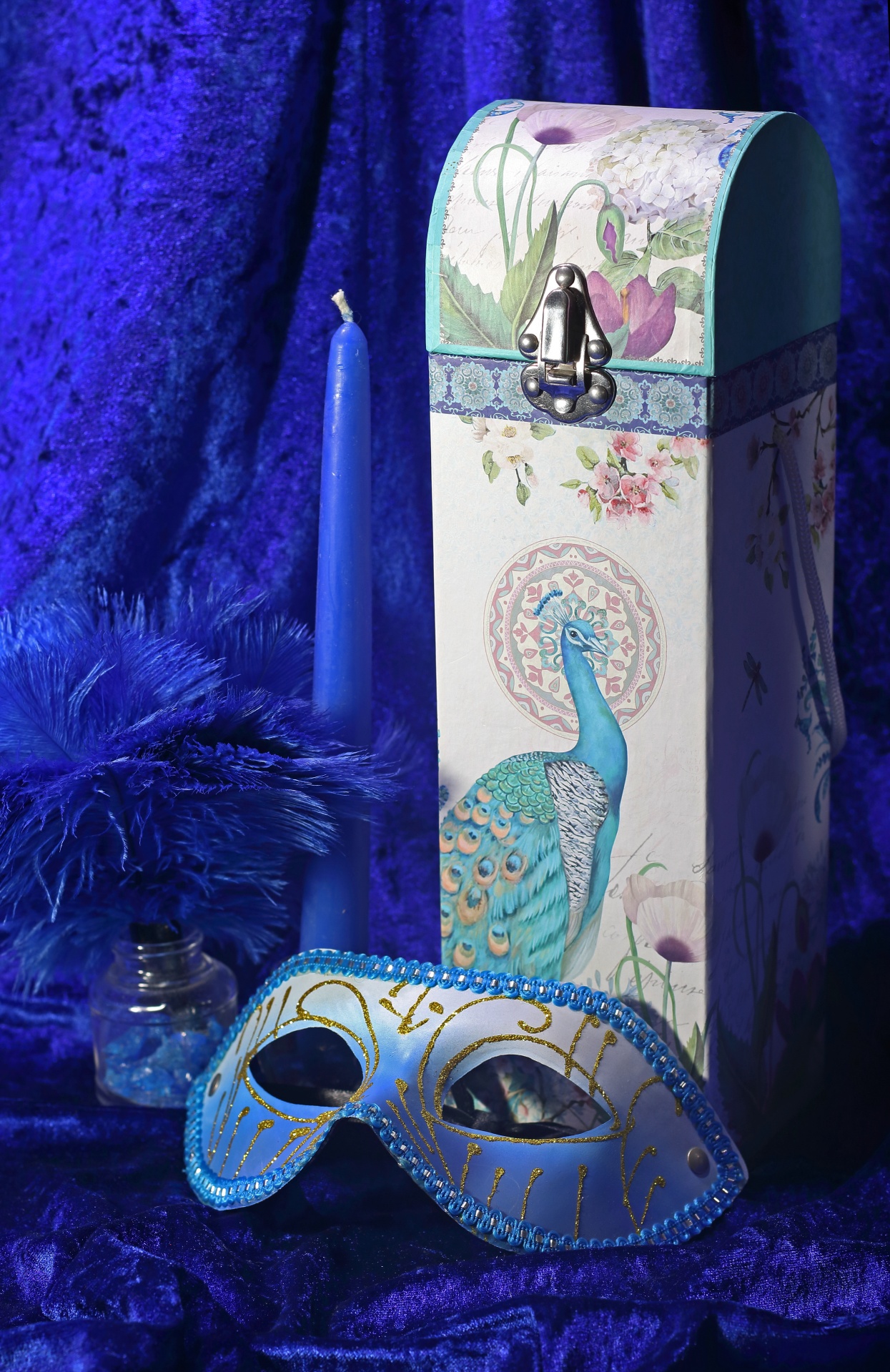 turquoise and white mask with decorative box and blue candle