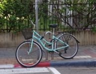 Green Bicycle Chained At Pavement