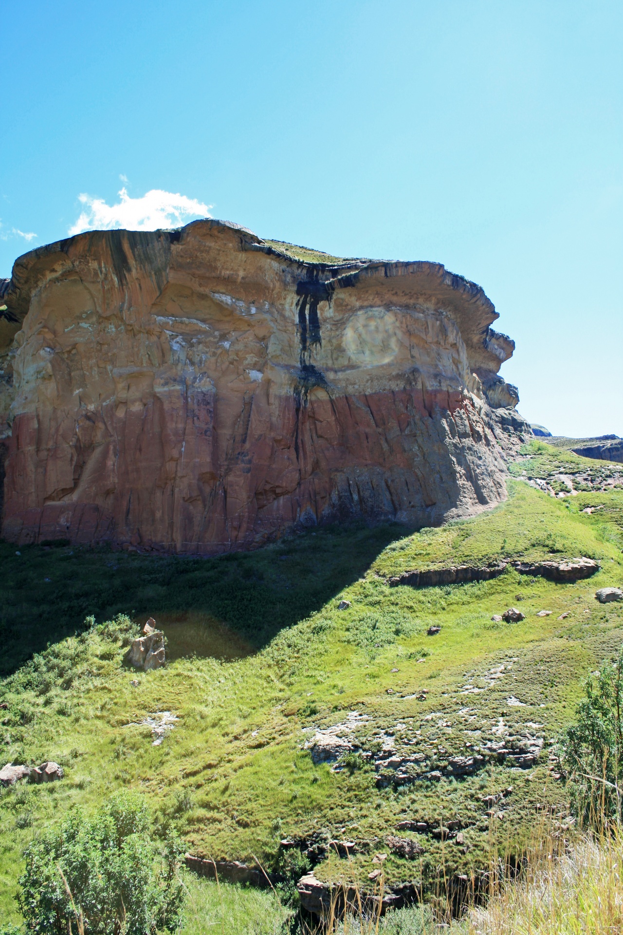 towering sandstone cliffs on green slopes in eastern free state, south africa