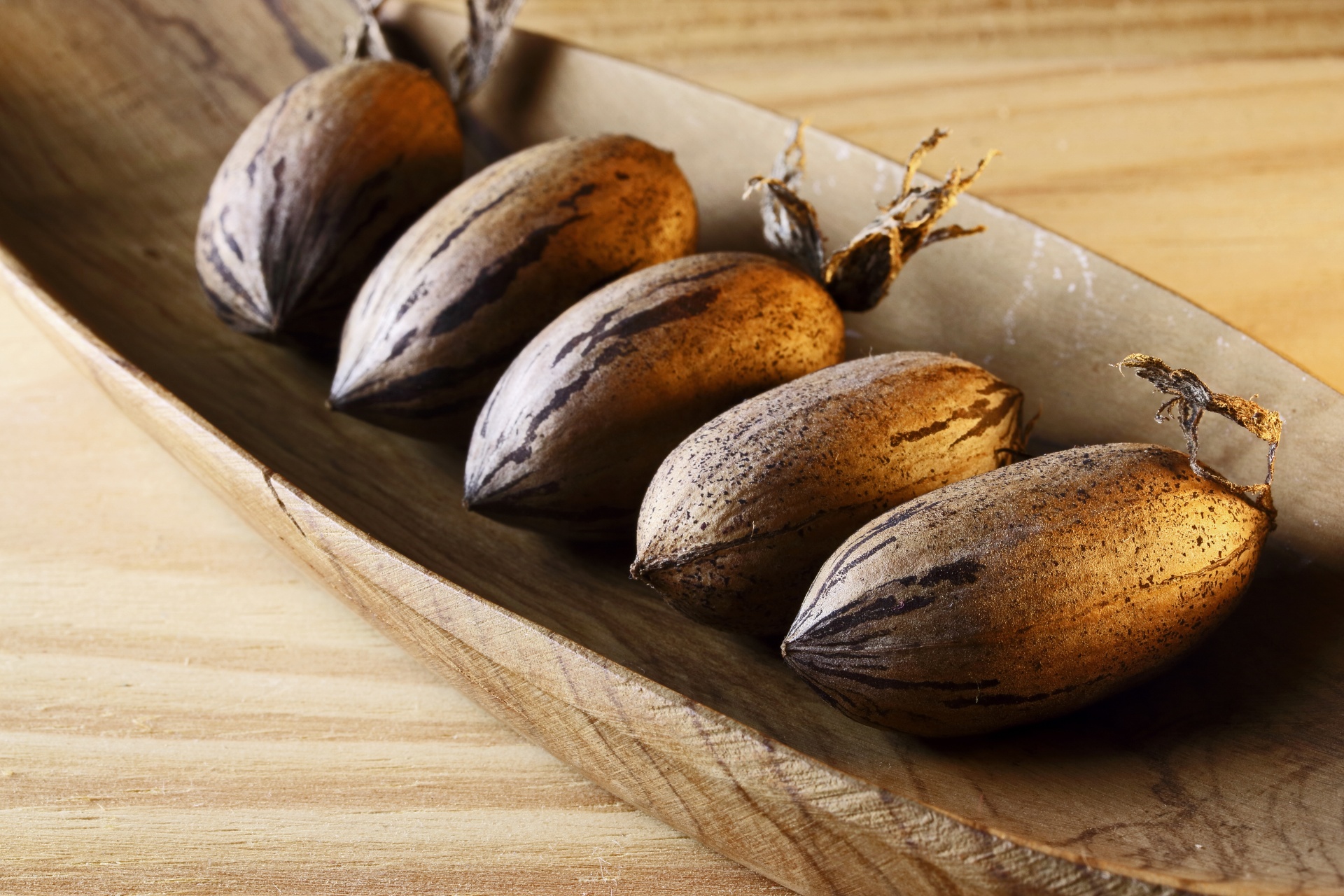 A Row Of Pecan Nuts In Wooden Bowl