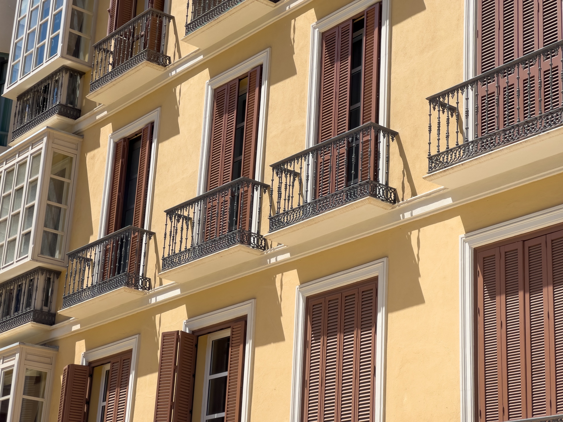 Windows and balconies with shutters on a historic building in Spain