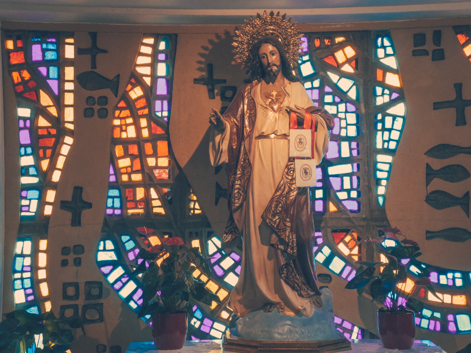 A statue of Jesus Christ with stained glass in a church