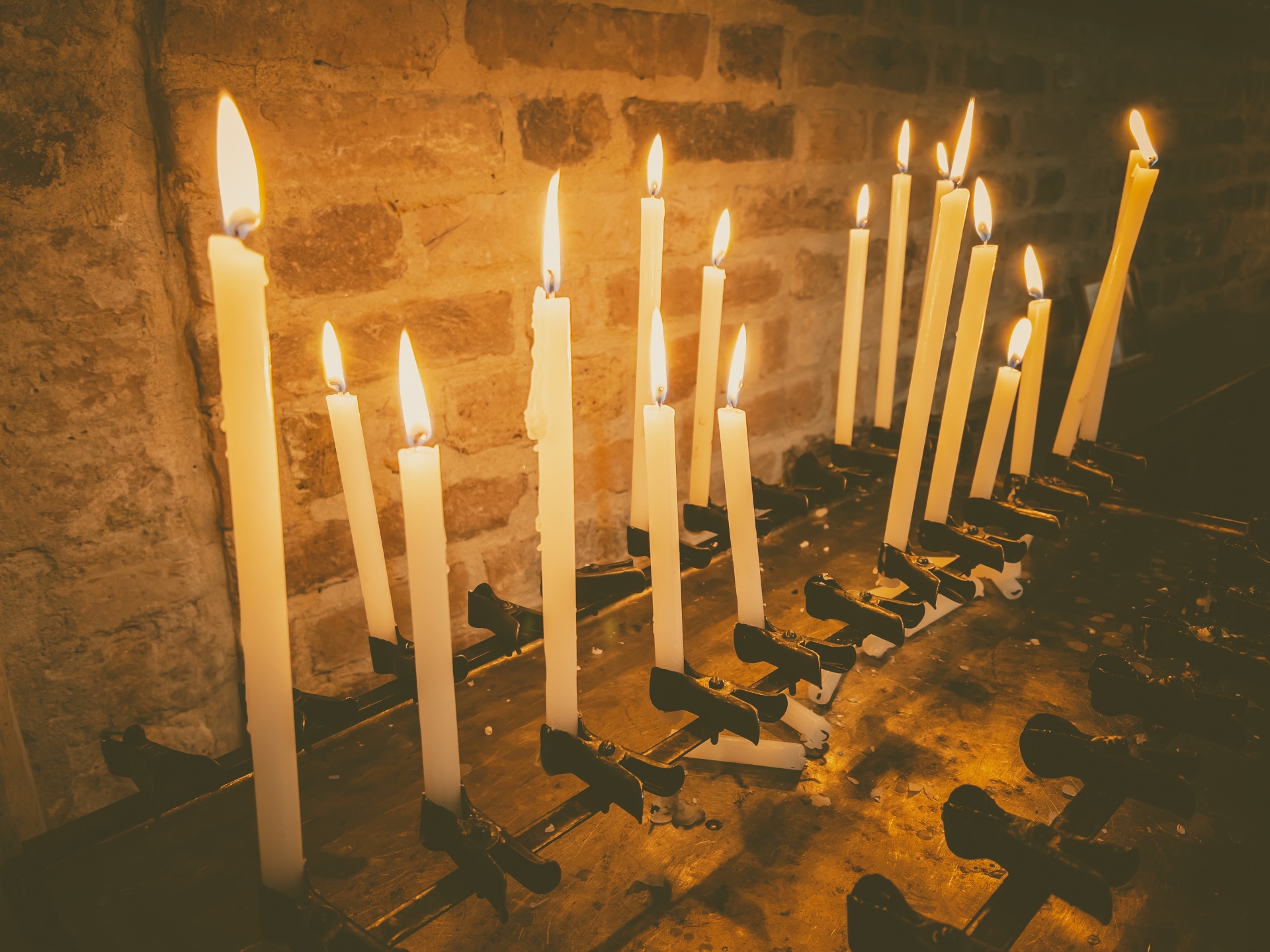 Thin long candles burning in a church