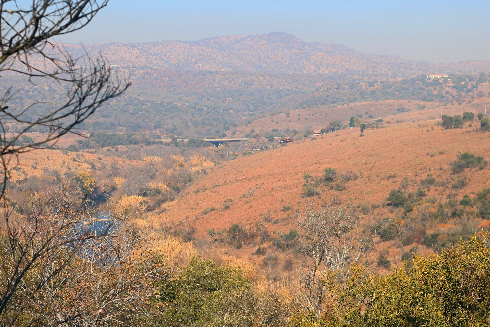 view over hills and slopes in a south african winter landscape with dry grassland and other vegetation