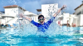 Boy Jumping In Pool On Holiday