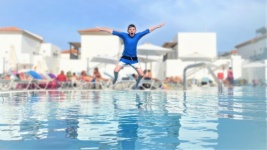 Boy Jumping Into Pool On Holiday