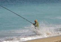 Fisherman Standing In Surf