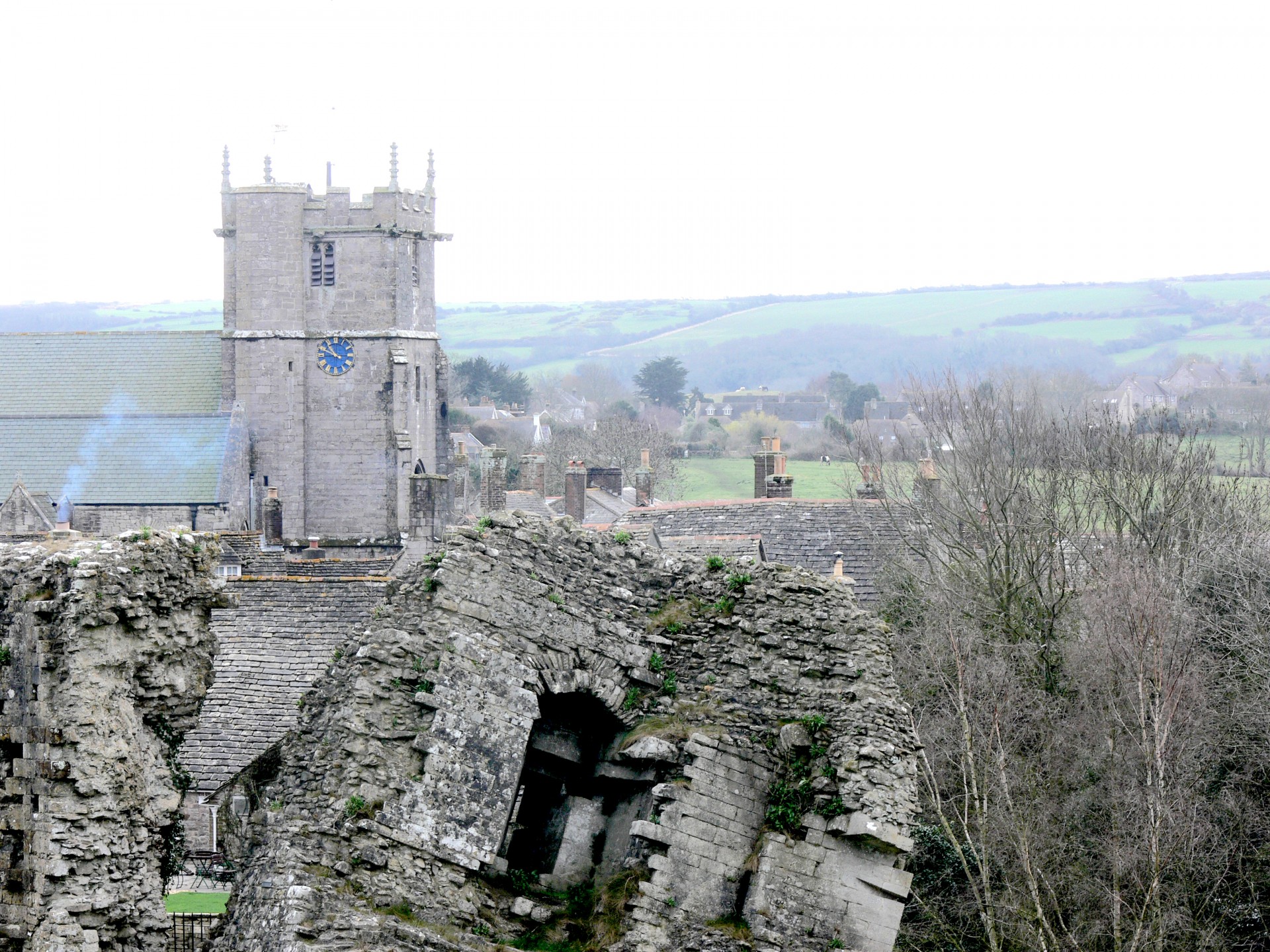 Looking over the broken castle wall towards the church in the village of Corfe