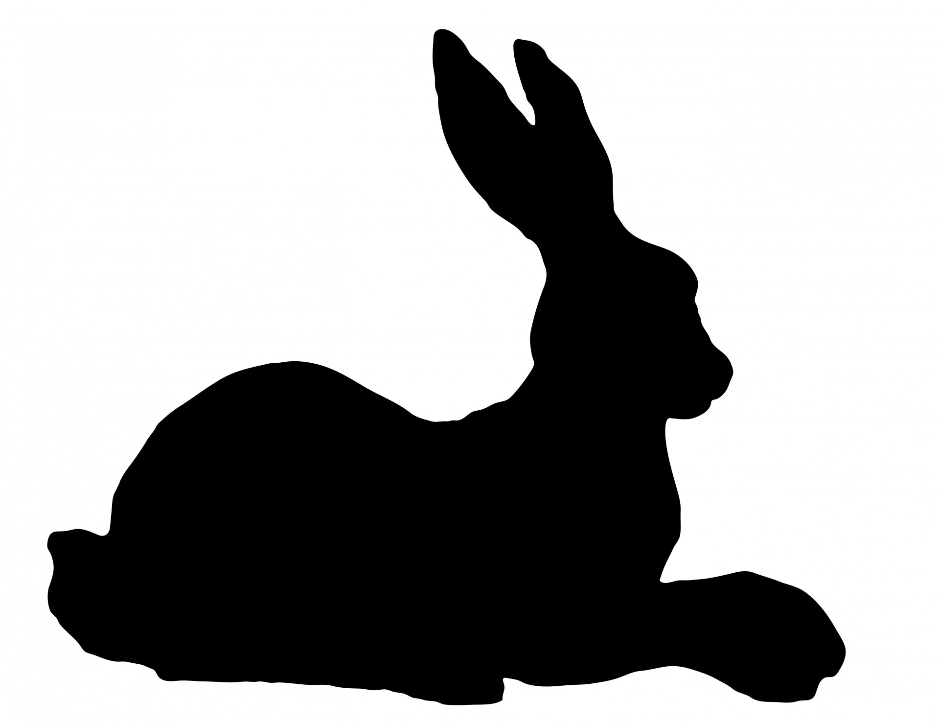 Black silhouette of a rabbit or hare laying down clipart
