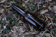 A Brown Beer Bottle On The Ground