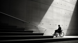 Wheelchair User Looking At Stairway