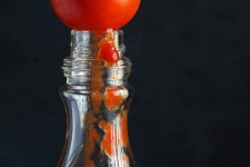 Tomato On Top Of A Glass Bottle