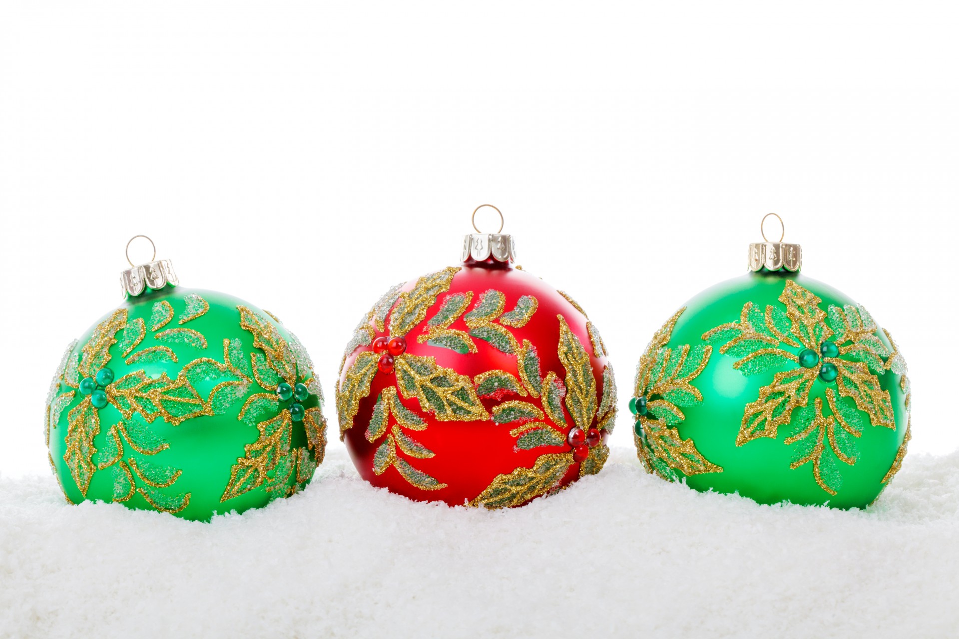 red and green christmas baubles in snow isolated on white background