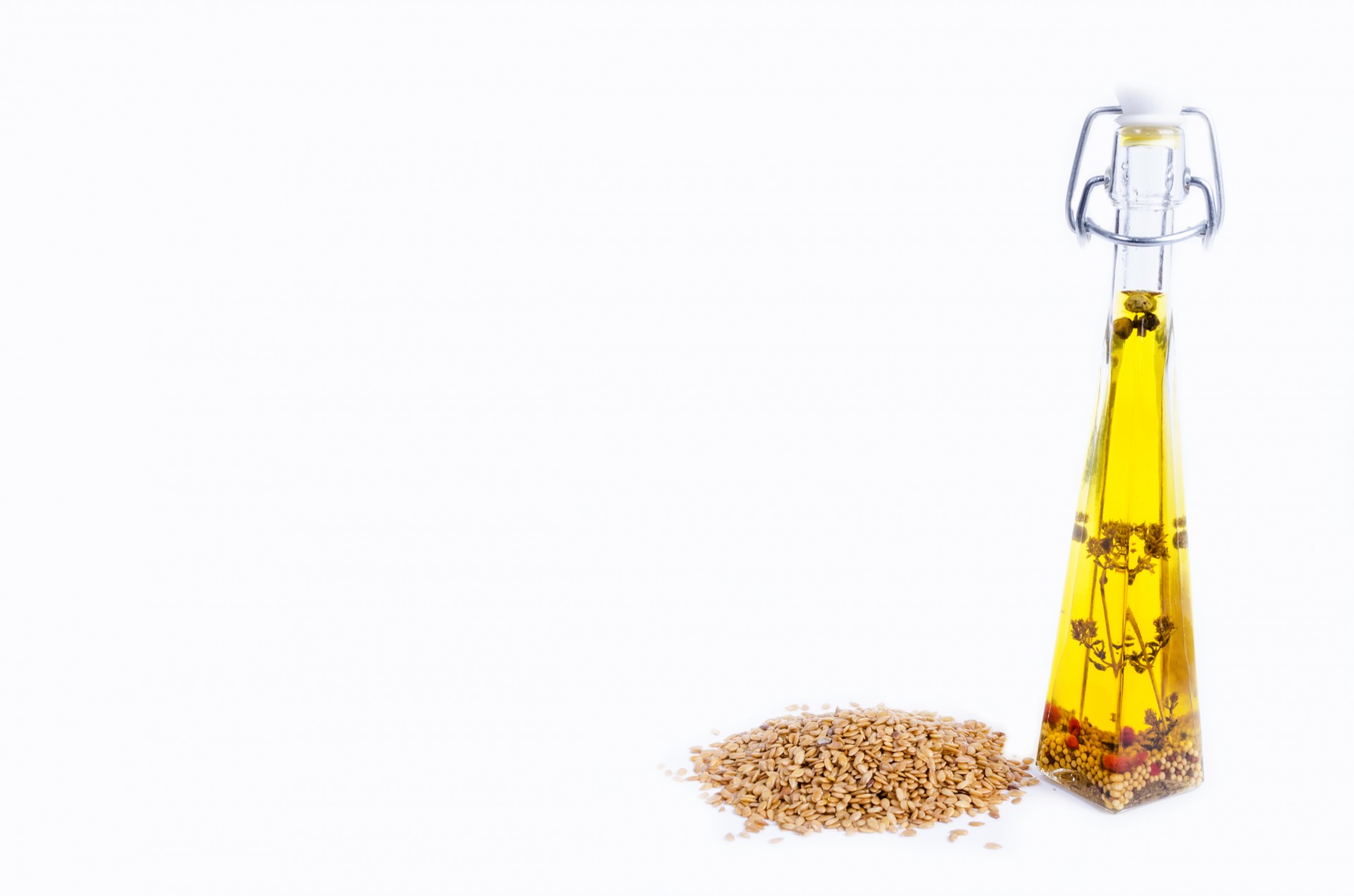 Sesame seeds and glass oil isolated on white background