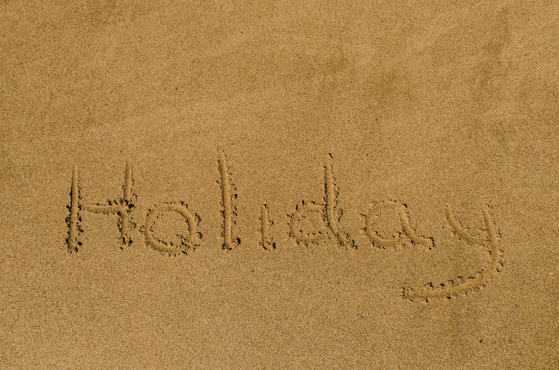 "Holiday" Written In The Sand